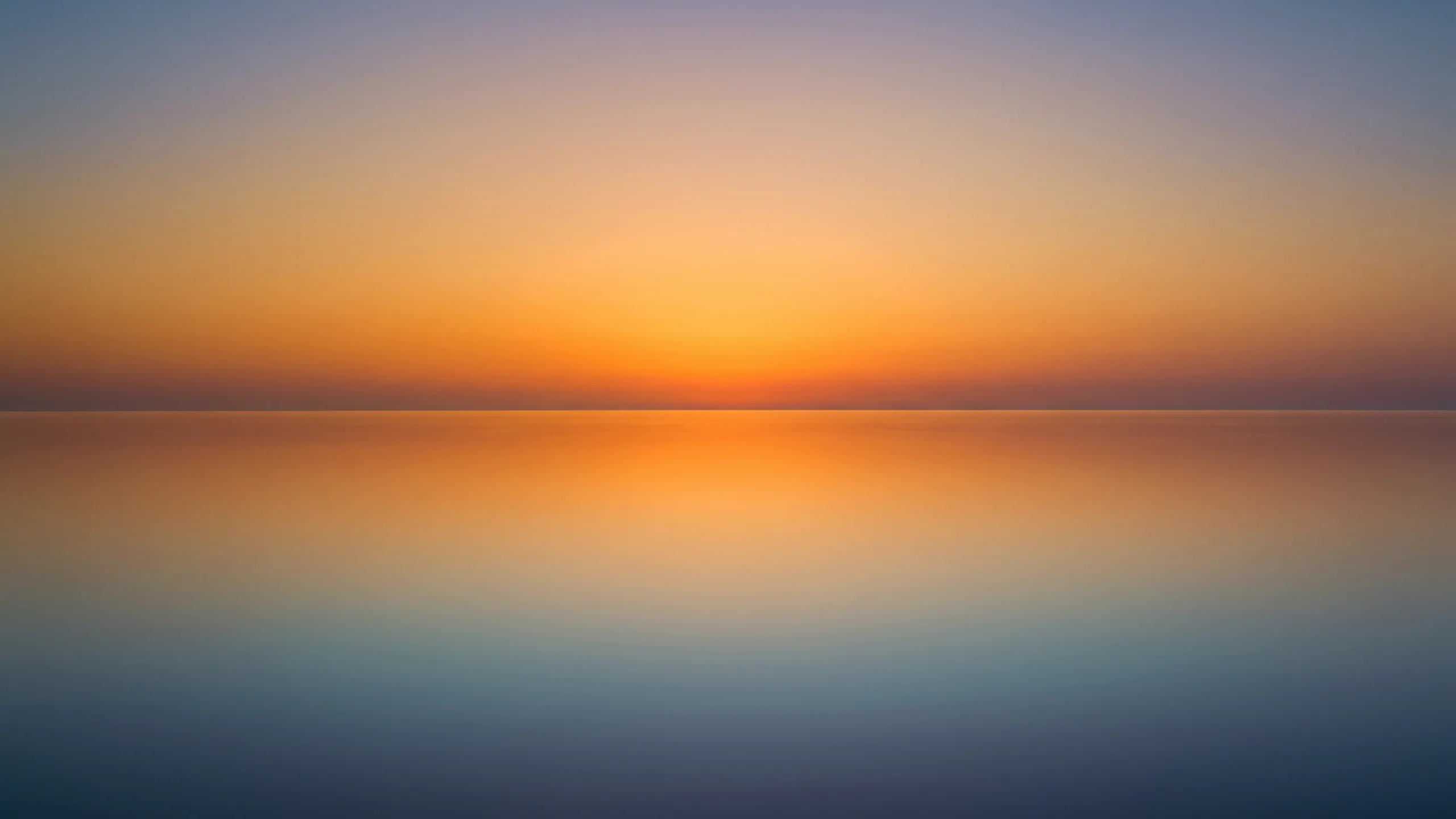 Still water mirroring a sunset sky